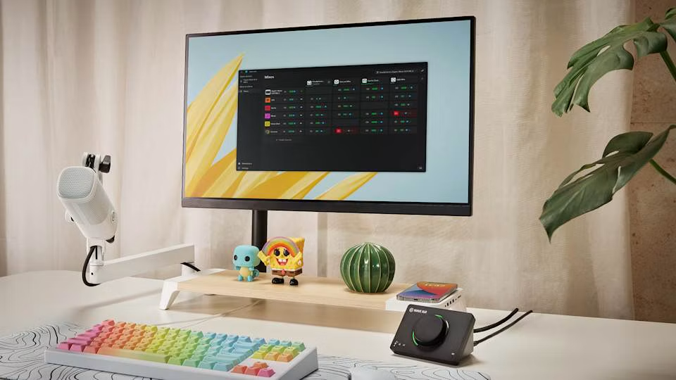 Cozy creative desk with a rainbow keyboard, white microphone and WaveXLR controller running the mixes app